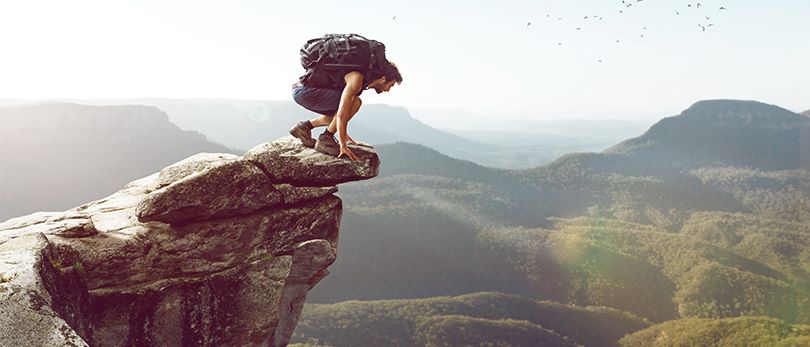 Homme accroupi pour regarder le vide et dompter son acrophobie