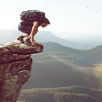 Homme accroupi pour regarder le vide et dompter son acrophobie